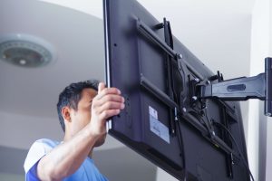 Technician wall mounting a TV